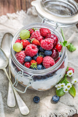 Closeup of granola with yogurt and flowers in sunny day