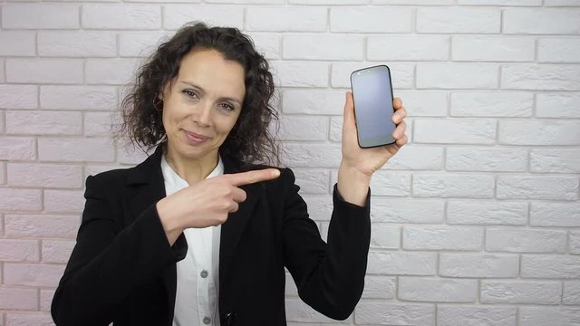 Happy woman showing phone.