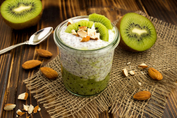 Pudding with chia and kiwi  on the rustic  wooden background