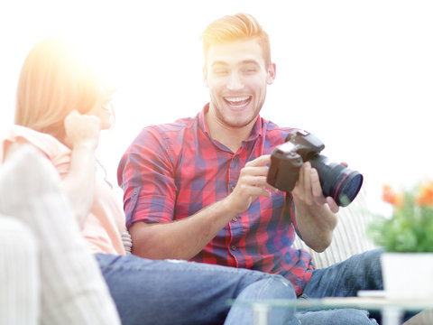 young man shows a photo of his girlfriend sitting in the living room