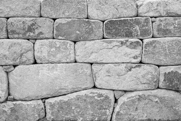 Close-up of an old stone wall texture background in black and white.