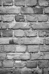 Old deteriorated brick wall texture background in black and white with vignetting.