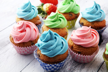 Tasty cupcakes on wooden background. Birthday cupcake in rainbow colors