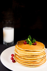 Delicious breakfast of fresh baked pancakes with milk and fresh cranberry homemade pastry