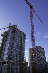 Fototapeta na wymiar Construction cranes on job site shot looking up