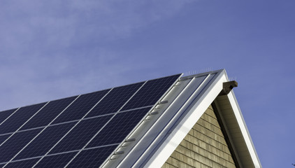 Fototapeta premium Solar panels on roof of house with sunny blue sky