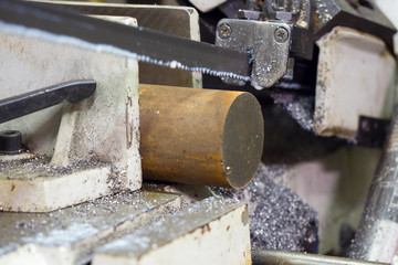 Band saw cutting metal, cooling emulsion, saw cuts metal contour disc.