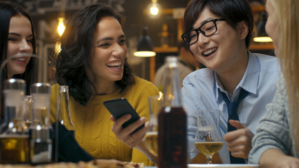 Diverse Group of Young People Have Fun in Bar, Talking, Telling Stories and Jokes. They Drink Various Drinks. They're in the Stylish Hipster Establishment.