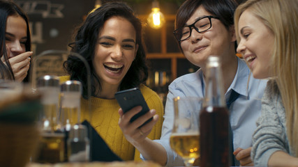 Diverse Group of Young People Have Fun in Bar, Talking, Telling Stories and Jokes. They Drink Various Drinks. They're in the Stylish Hipster Establishment.