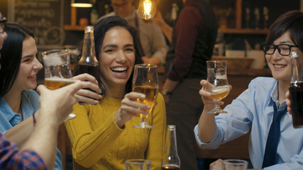 Diverse Group of Beautiful Young People Make a Toast and Clink Raised Glasses with Various Drinks in Celebration.