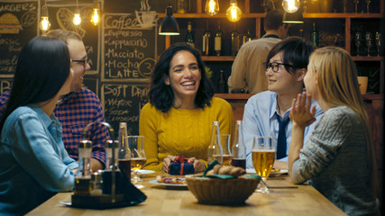 In the Bar/ Restaurant Beautiful Hispanic Woman Receives Gifts and Congratulations From Her Best Friends. Everybody is Happy!