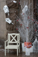 wooden santa chair near white trees and boxes with presents