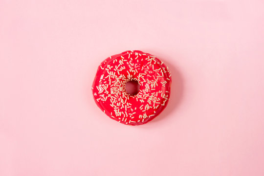 red round donut on the center of a pink background