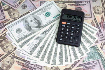 Fototapeta premium calculator green notebook with dollar bills on the background of money borrowed money concept