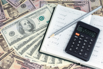 calculator green notebook with dollar bills on the background of money pension scheme concept