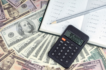 calculator green notebook with dollar bills on the background of money pension scheme concept