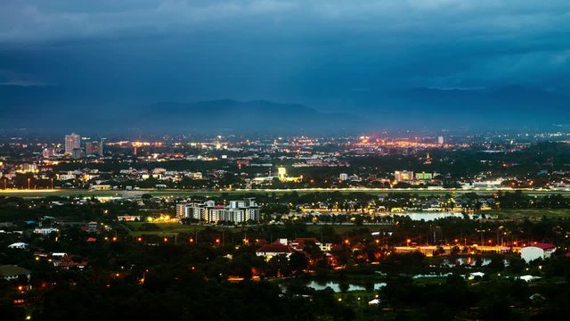 Chiang Mai, Thailand. Aerial view of Chiang Mai, Thailand in the evening. Time-lapse at sunset of illuminated buidings and forest. Cloudy blue sky