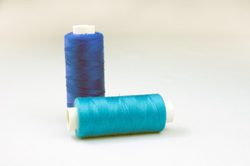 blue threads on reels selective focus, white background