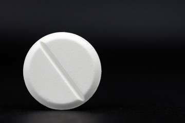 white round tablets painkiller copy space, black background, selective focus