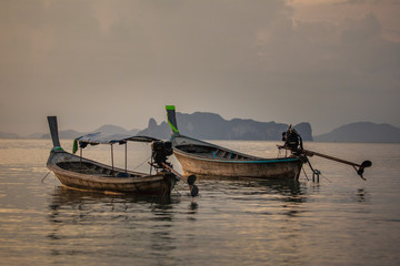 Classic Thailand sunset view with long tail boats