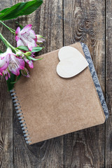 notebook with heart on wooden background