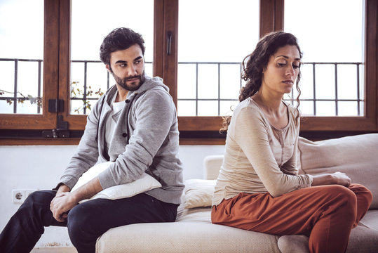 Couple not talking after a fight on the sofa in living room at home