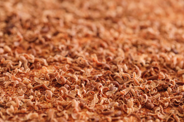 Chocolate flakes, extreme macro. Close up of fine chocolate chips and curls chopped by hand on cake texture. Best picture of tasty chocolate curls shavings.