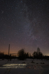 The milky way winter, a clear night over the meadow and trees.