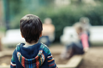 Fototapeta premium Adorable little boy with autumn leaves in the beauty park, sitting on the ground