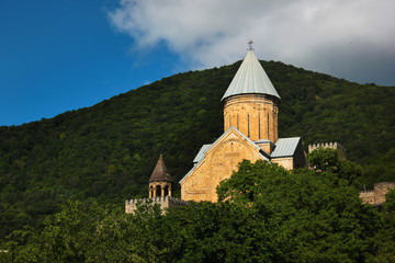 Fototapeta na wymiar Medieval castle complex with church on Jinvali water reservoir, Aragvi river, Ananuri, Georgia