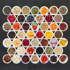 Health food for a healthy heart with chinese and ayurvedic herbal medicine, vegetables, fruit, nuts, seeds, pulses, cereals and grains and herbs on  slate. High in omega 3, antioxidants & anthocyanins