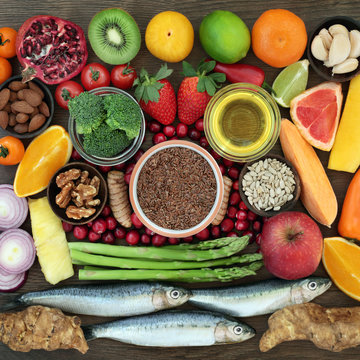 Super food for a healthy lifestyle concept with foods high in omega 3, antioxidants, anthocyanins and vitamins with fresh sardines, fruit, vegetables, seeds, nuts, herbs, spice and olive oil.
