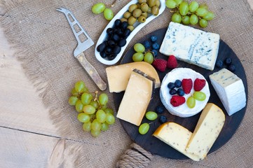 Cheese platter with different cheese and grapes and berries