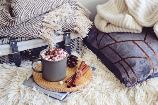 Cozy home with cup of coffee with  blanket and book. Hygge home interior 