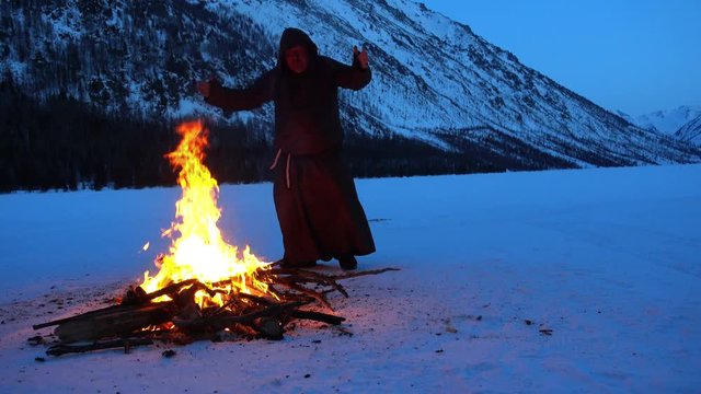 a mad monk dances around the campfire