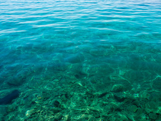 Fototapeta na wymiar Turquoise transparent water off the coast of the Mediterranean Sea on a sunny summer day