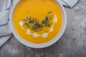 Delicious creamy homemade pumpkin soup with cream and pumpkin seed garnish.