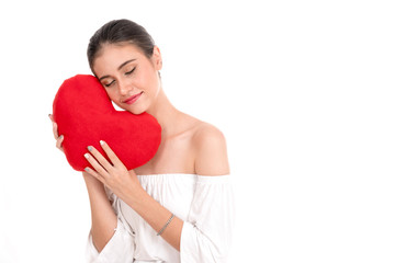 Happy beautiful young woman holding red cushion heart shape smiling isolated in white background with copyspace.love romance and valentines day concept.