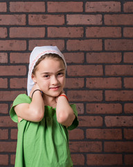 Girl with milk mustache posing with a brick wall background.