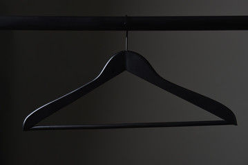 A black coat hanger and closet rod - obrazy, fototapety, plakaty