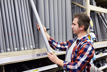 Man chooses plastic sewer pipes in building store