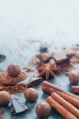 Cooking desserts and home concept. Chocolate pieces, spices, anise stars, cinnamon and cocoa on a stone background. Ingredients close-up.