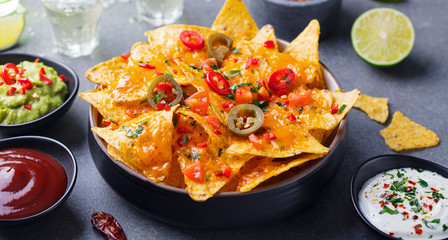 Nachos chips with melted cheese and dips variety