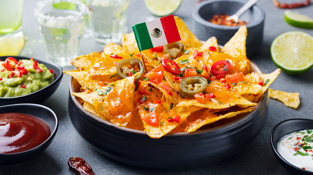 Nachos chips with Mexican flag and dips variety.