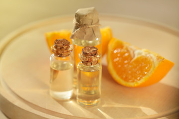 essential orange oil . oil orange in transparent glass bottles and orange slice on a  wooden board on a blurred beige background. organic cosmetics concept