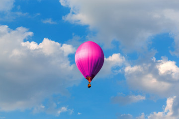 purple hot air balloons flying in blue sky with clouds