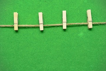 Wood clip hanging on to the grass green moist.