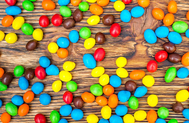 Fototapeta na wymiar Background of colorful candies on wooden table.