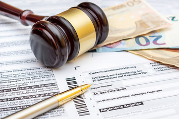 Money, gavel and pen on the German tax form. 