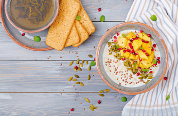 Tasty and healthy oatmeal porridge with mango, pomegranate and seeds. Healthy breakfast. Fitness food. Proper nutrition. Top view